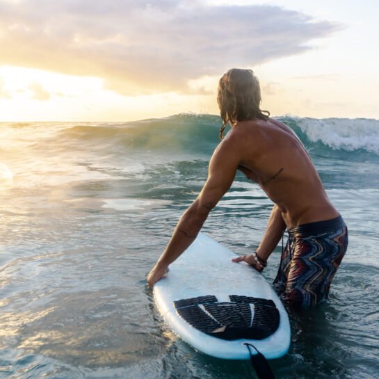 Young caucasian man get up early to  doing surf at sunrise